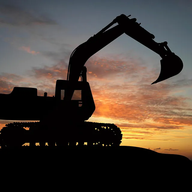 Gravemaskin i solnedgang